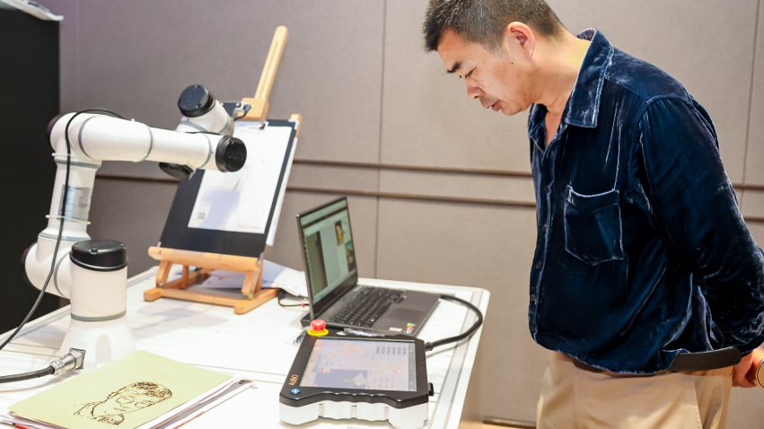 嘉賓體驗(yàn)遨博AI繪畫機(jī)器人。主辦方供圖